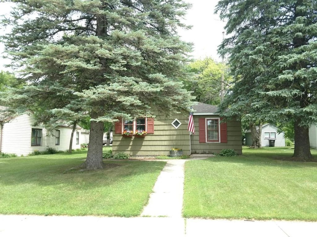 1117 7th St SW, Willmar, MN 56201 - obstructed view of property with a front yard and a shingled roof
