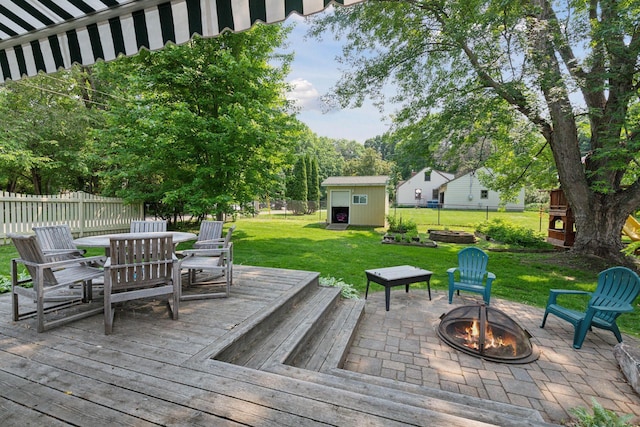 18805 Azure Rd, Deephaven, MN 55391 - wooden deck with an outdoor fire pit, outdoor dining space, a storage shed, a fenced backyard, and a patio area