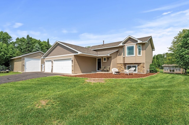 18125 Fillmore St NE, East Bethel, MN 55011 - tri-level home featuring an attached garage, asphalt driveway, stone siding, a front yard, and roof with shingles