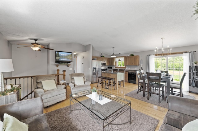 18125 Fillmore St NE, East Bethel, MN 55011 - living room featuring a ceiling fan, lofted ceiling, light wood-style flooring, and a textured ceiling
