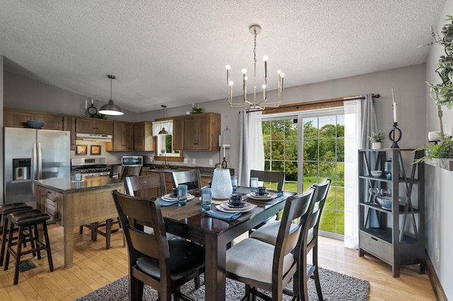 18125 Fillmore St NE, East Bethel, MN 55011 - dining area with a chandelier, light wood finished floors, a textured ceiling, and lofted ceiling