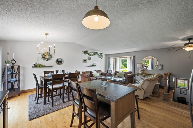 18125 Fillmore St NE, East Bethel, MN 55011 - dining space with a textured ceiling, light wood-type flooring, a chandelier, ceiling fan, and vaulted ceiling