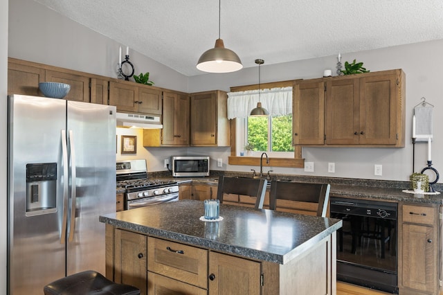 18125 Fillmore St NE, East Bethel, MN 55011 - kitchen with stainless steel appliances, under cabinet range hood, dark countertops, a textured ceiling, and decorative light fixtures