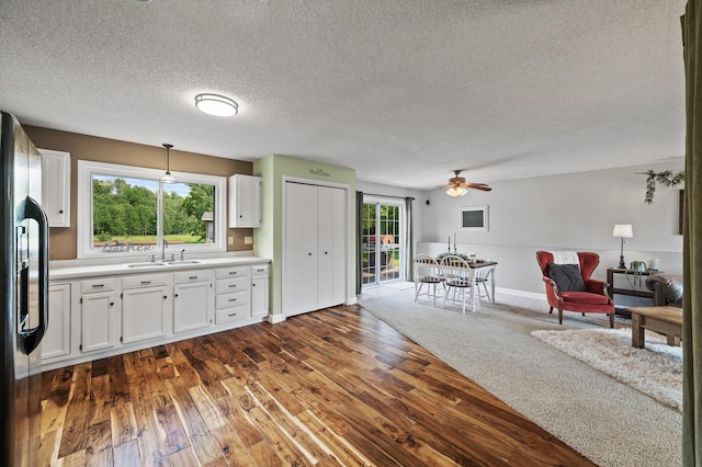 18125 Fillmore St NE, East Bethel, MN 55011 - kitchen featuring refrigerator with ice dispenser, open floor plan, white cabinetry, light countertops, and dark wood-style floors