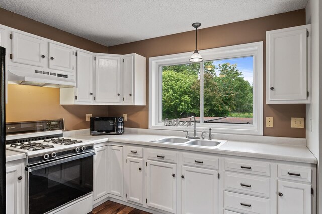 18125 Fillmore St NE, East Bethel, MN 55011 - kitchen with gas range gas stove, under cabinet range hood, white cabinets, light countertops, and a textured ceiling