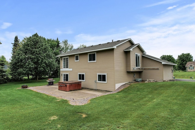 18125 Fillmore St NE, East Bethel, MN 55011 - back of property featuring a hot tub, a patio area, a lawn, and an outdoor fire pit