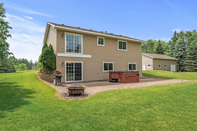 18125 Fillmore St NE, East Bethel, MN 55011 - rear view of house featuring a hot tub, a fire pit, a patio area, and a lawn