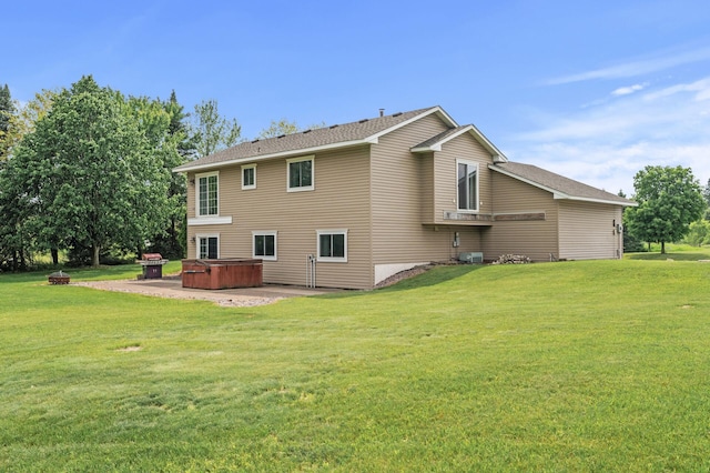 18125 Fillmore St NE, East Bethel, MN 55011 - rear view of property featuring a hot tub, a lawn, a patio area, and an outdoor fire pit