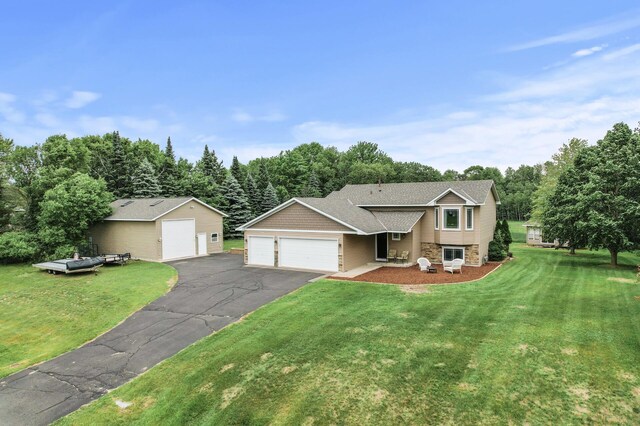 18125 Fillmore St NE, East Bethel, MN 55011 - split level home with stone siding, a front yard, an attached garage, and asphalt driveway