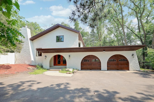 1919 Timberline Spur, Minnetonka, MN 55305 - mediterranean / spanish-style home with stucco siding, asphalt driveway, a chimney, and french doors