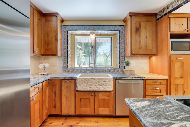 1919 Timberline Spur, Minnetonka, MN 55305 - kitchen with stainless steel appliances, brown cabinets, tasteful backsplash, and light wood finished floors
