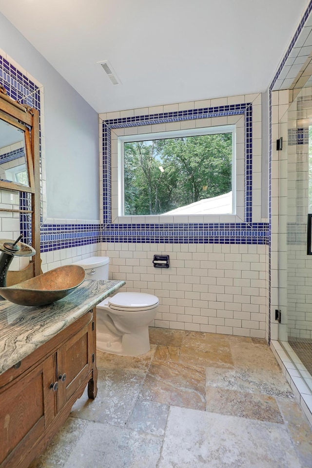 1919 Timberline Spur, Minnetonka, MN 55305 - full bathroom featuring stone tile floors, tile walls, vanity, and a stall shower