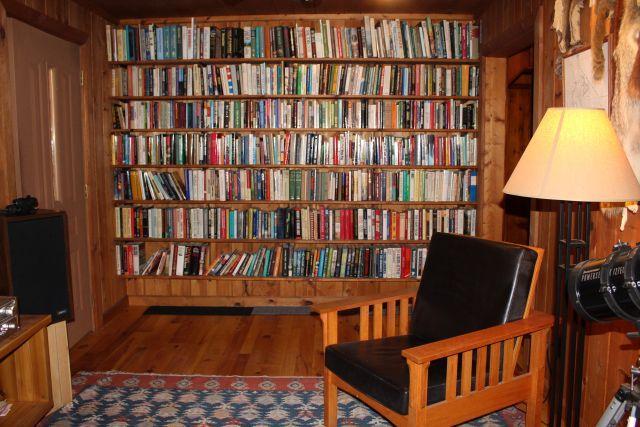 32704 310th Ln, Aitkin, MN 56431 - sitting room featuring bookshelves, wood finished floors, and wooden walls