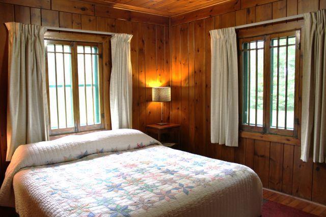 32704 310th Ln, Aitkin, MN 56431 - bedroom with wooden walls, wooden ceiling, multiple windows, and wood finished floors