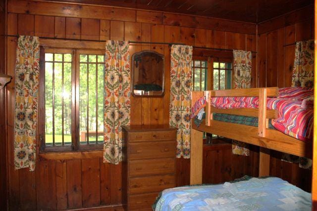 32704 310th Ln, Aitkin, MN 56431 - bedroom with wood walls, multiple windows, and wood ceiling