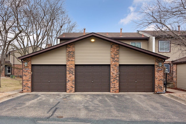 2436 Mendelssohn Ln N, Golden Valley, MN 55427 - view of front of house with brick siding, asphalt driveway, an attached garage, and roof with shingles