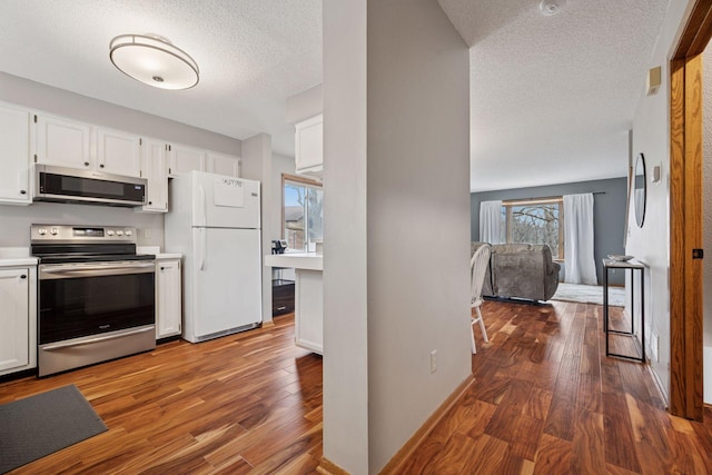 2436 Mendelssohn Ln N, Golden Valley, MN 55427 - kitchen with stainless steel appliances, a textured ceiling, white cabinets, dark wood-type flooring, and light countertops