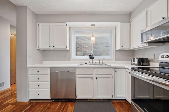 2436 Mendelssohn Ln N, Golden Valley, MN 55427 - kitchen with stainless steel appliances, a sink, white cabinets, dark wood-type flooring, and light countertops