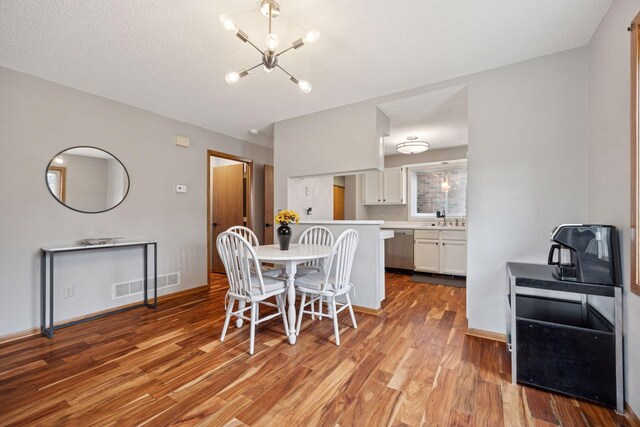 2436 Mendelssohn Ln N, Golden Valley, MN 55427 - dining area featuring a chandelier, light wood finished floors, and baseboards