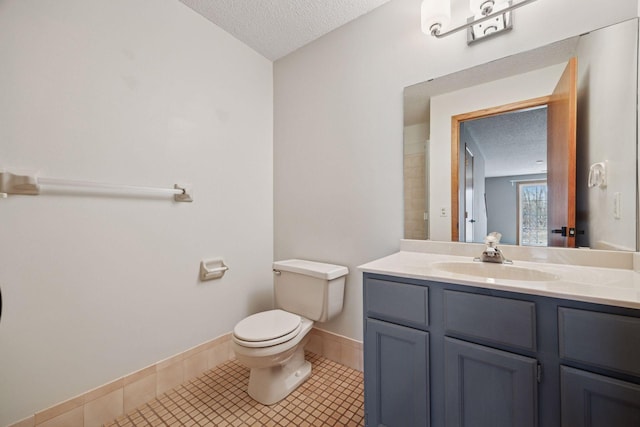 2436 Mendelssohn Ln N, Golden Valley, MN 55427 - bathroom with a textured ceiling, toilet, vanity, tile patterned flooring, and baseboards