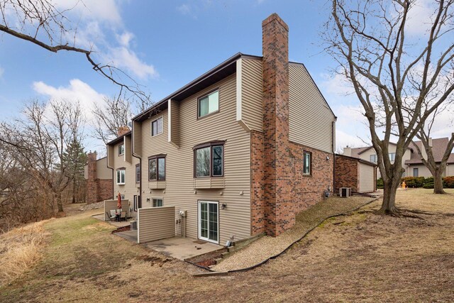 2436 Mendelssohn Ln N, Golden Valley, MN 55427 - rear view of house with a patio area, a chimney, and brick siding