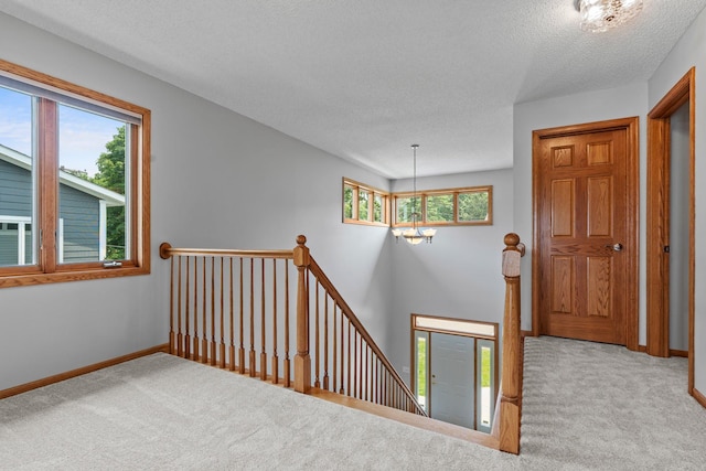 3868 Green Heights Trl SW, Prior Lake, MN 55372 - hallway featuring an upstairs landing, carpet, a textured ceiling, and a chandelier