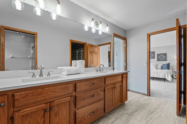 3868 Green Heights Trl SW, Prior Lake, MN 55372 - ensuite bathroom featuring double vanity, wood finished floors, a textured ceiling, and an enclosed shower