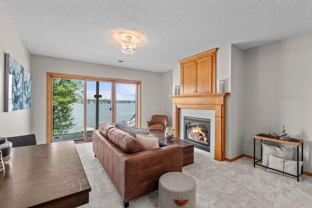 3868 Green Heights Trl SW, Prior Lake, MN 55372 - living room featuring a tiled fireplace, light carpet, a water view, and a textured ceiling