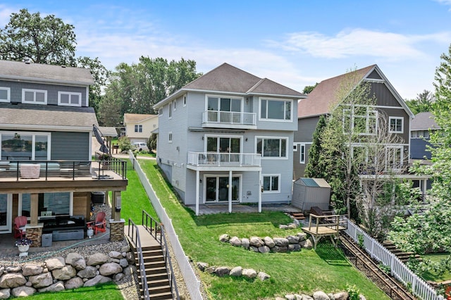 3868 Green Heights Trl SW, Prior Lake, MN 55372 - back of house featuring a storage unit, a patio area, stairway, a balcony, and a fenced backyard