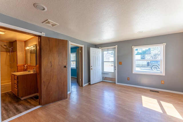 25 4th Ave, Soudan, MN 55782 - unfurnished bedroom with wood finished floors, a textured ceiling, and baseboards