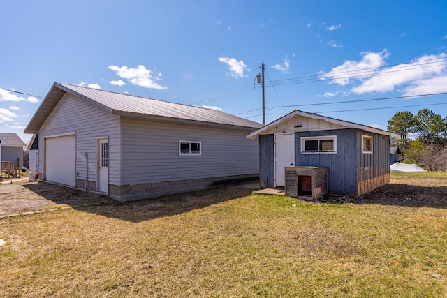 25 4th Ave, Soudan, MN 55782 - back of house with an outbuilding, a yard, a detached garage, and metal roof