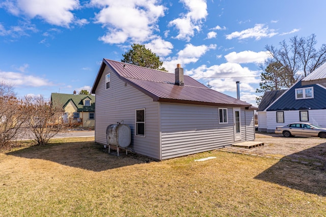 25 4th Ave, Soudan, MN 55782 - view of side of property featuring metal roof, a chimney, a lawn, and heating fuel