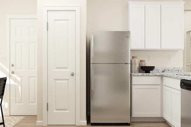 18736 Ivanhoe St NW, Elk River, MN 55330 - kitchen with appliances with stainless steel finishes, white cabinetry, light stone counters, and light wood-type flooring