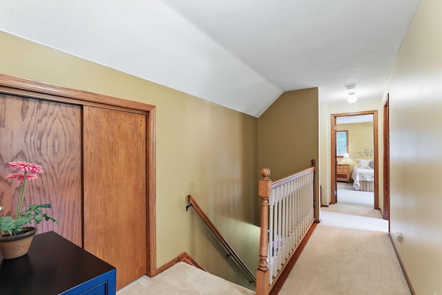2657 Valley View Ln, New Brighton, MN 55112 - hall with an upstairs landing, light colored carpet, vaulted ceiling, and a textured ceiling