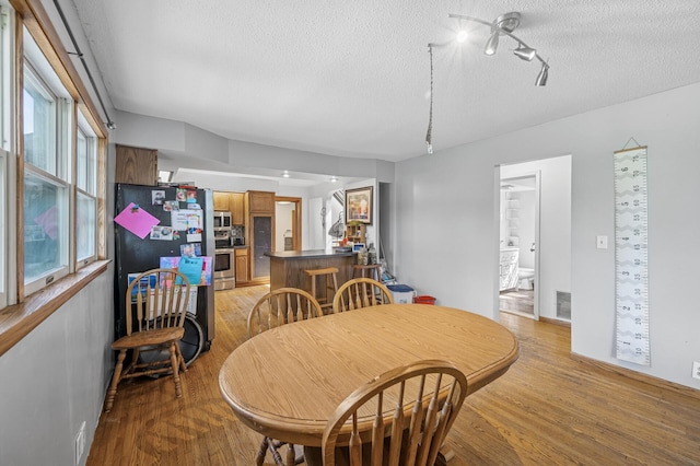 132 Middle School Dr, Saint Croix Falls, WI 54024 - dining area with light wood-style flooring and a textured ceiling