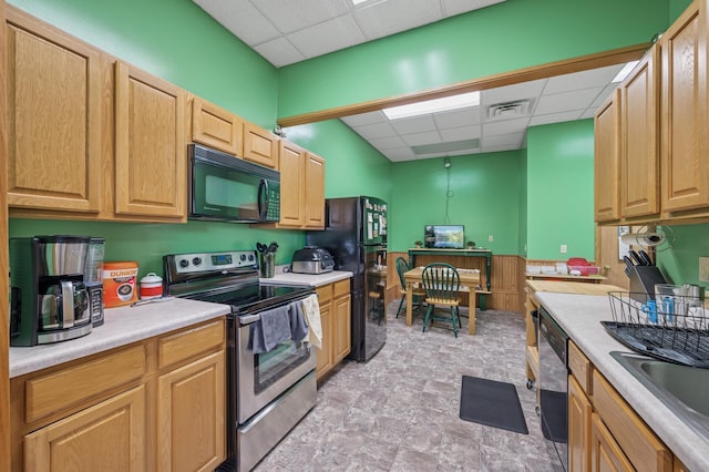 132 Middle School Dr, Saint Croix Falls, WI 54024 - kitchen with black appliances, a drop ceiling, light countertops, a sink, and stone finish flooring