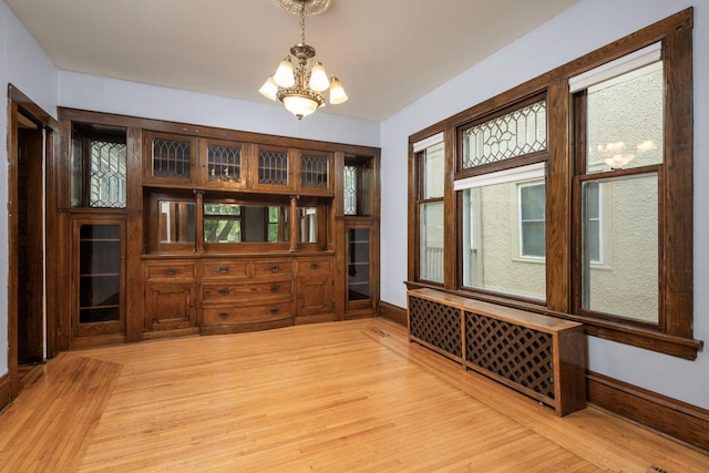 3225 Hennepin Ave, Minneapolis, MN 55408 - dining area featuring light wood-style flooring, a chandelier, plenty of natural light, and baseboards