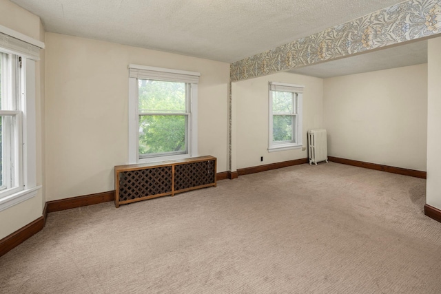 3225 Hennepin Ave, Minneapolis, MN 55408 - carpeted empty room featuring radiator, healthy amount of natural light, baseboards, and a textured ceiling