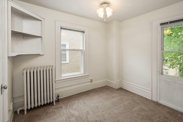 3225 Hennepin Ave, Minneapolis, MN 55408 - spare room featuring radiator, carpet flooring, plenty of natural light, and ceiling fan
