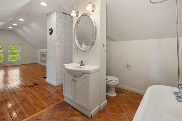 3225 Hennepin Ave, Minneapolis, MN 55408 - full bath featuring lofted ceiling, a soaking tub, vanity, recessed lighting, and baseboards