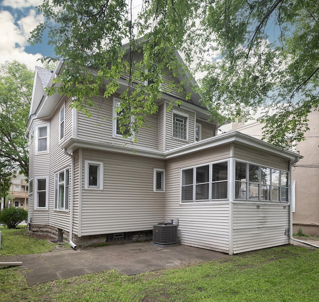 3225 Hennepin Ave, Minneapolis, MN 55408 - back of house featuring central AC unit, a patio area, a yard, and a sunroom