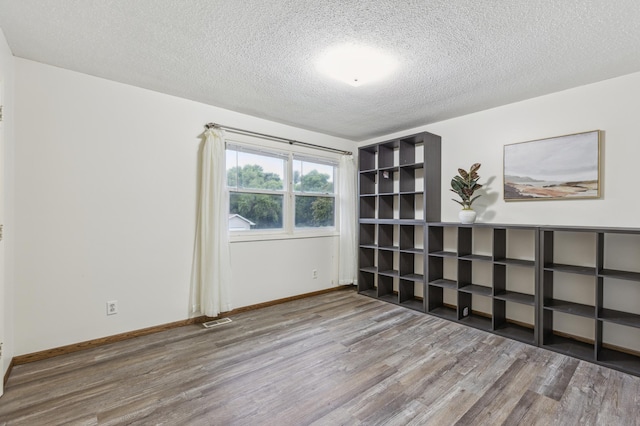902 Ridge Dr SE, Saint Michael, MN 55376 - spare room featuring wood finished floors and a textured ceiling