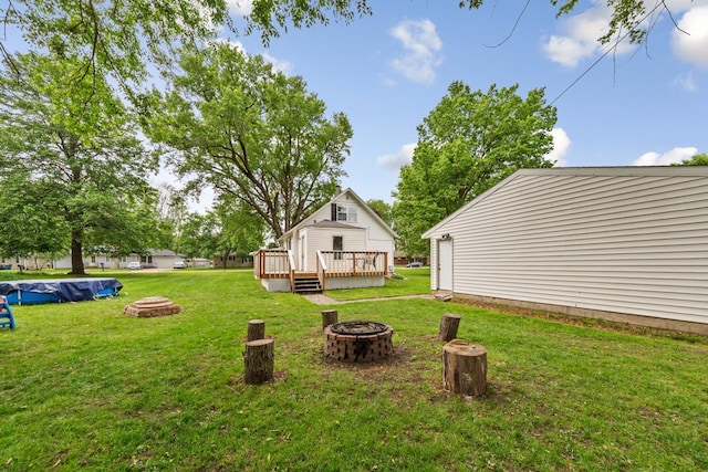 1039 9th Ave SW, Faribault, MN 55021 - view of green lawn featuring a fire pit and a wooden deck