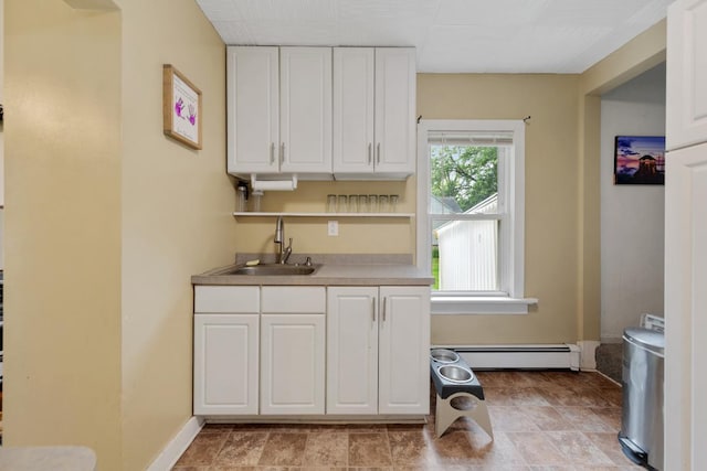 1039 9th Ave SW, Faribault, MN 55021 - kitchen featuring a baseboard heating unit, a sink, white cabinets, baseboards, and open shelves