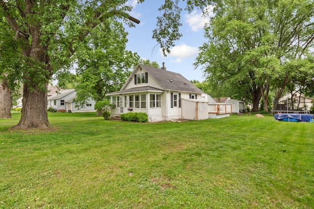 1039 9th Ave SW, Faribault, MN 55021 - rear view of house with a lawn, a deck, a chimney, and a sunroom