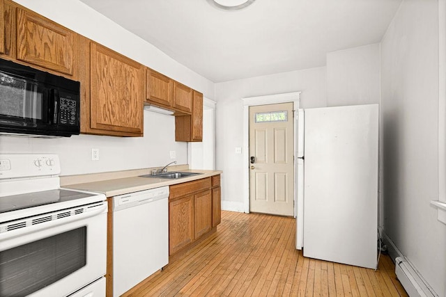 1901 5th St, Duluth, MN 55812 - kitchen with white appliances, a sink, a baseboard heating unit, light wood-style flooring, and light countertops