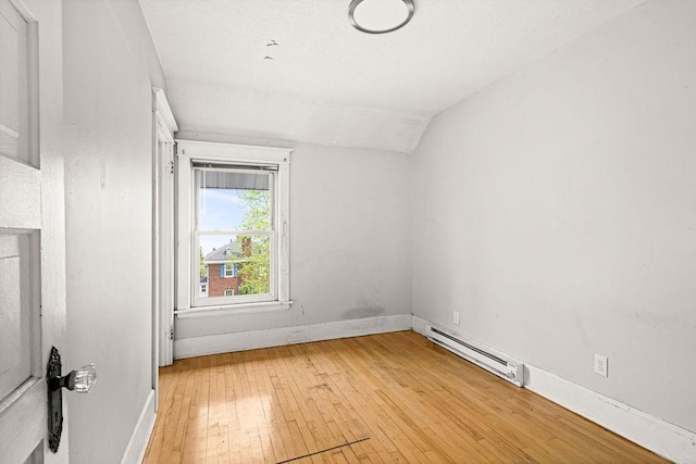 1901 5th St, Duluth, MN 55812 - empty room with baseboard heating, lofted ceiling, light wood finished floors, and baseboards