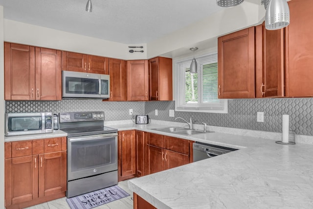 495 Saint Anthony Ave, Saint Paul, MN 55103 - kitchen featuring stainless steel appliances, light countertops, decorative backsplash, pendant lighting, and a textured ceiling