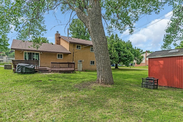 495 Saint Anthony Ave, Saint Paul, MN 55103 - rear view of property with stucco siding, a lawn, a deck, and an outdoor structure