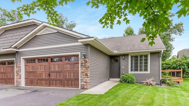 2811 Swallowtail Ct, Altoona, WI 54720 - view of front facade with stone siding, a garage, a front lawn, and roof with shingles